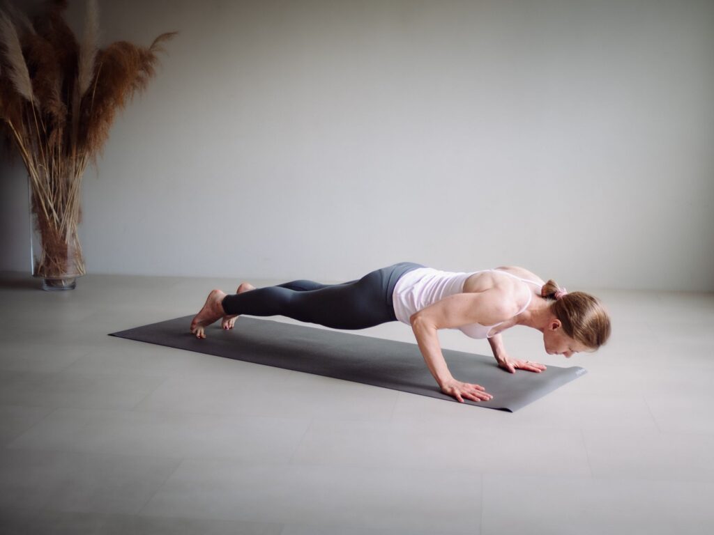 Ela Buchholz hält Chaturanga Dandasana, die kraftvolle tiefe Position im Ashtanga Yoga