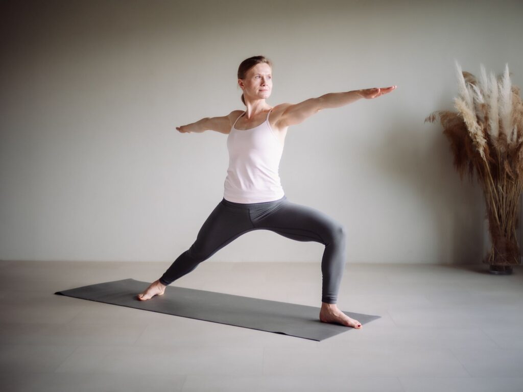 Yogalehrerin Ela Buchholz steht kraftvoll und ruhig im Krieger II